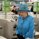 Queen Elizabeth II looks at products on the shelves at a Waitrose supermarket during a visit to the town of Poundbury on October 27, 2016 in Poundbury, Dorset. Photo via Getty Images.